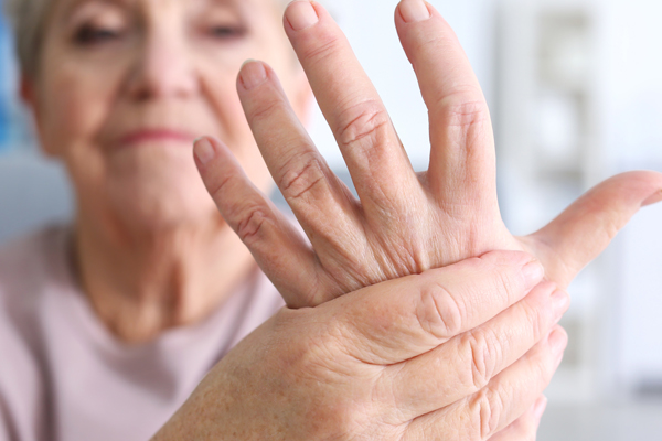 Elderly woman suffering from pain in hand, closeup